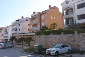 un'auto bianca parcheggiata di fronte a un muro di mattoni di Apartments and rooms with WiFi Vrsar, Porec - 3007 a Vrsar