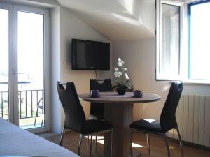 a room with a table and chairs and a tv at Apartments and rooms with parking space Bol, Brac - 2926 in Bol +21 photos