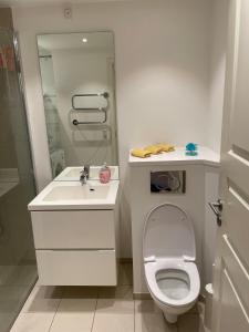 a white bathroom with a toilet and a sink at CPH Lux Apartments KH in Copenhagen