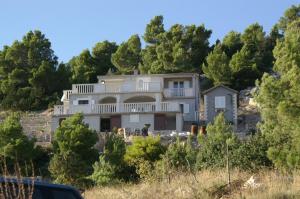 una casa en la cima de una colina con árboles en Apartment Vela Farska 2897b en Murvica