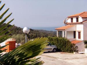 un coche aparcado frente a una casa con el océano en Apartments and rooms with WiFi Vrsar, Porec - 3007, en Vrsar