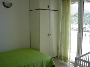 Un dormitorio con una cama verde y una ventana en Apartment Vela Farska 2897b en Murvica