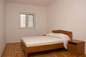 a white bedroom with a bed and a window at Apartments with a parking space Vinisce, Trogir - 2987 in Vinišće