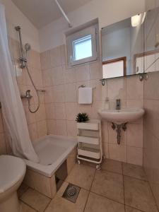 a bathroom with a tub and a sink and a toilet at Studio Duce 2821a in Duće
