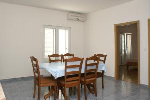a dining room with a table and chairs at Apartments with a parking space Vinisce, Trogir - 2987 in Vinišće