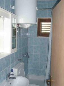 baño de azulejos azules con lavabo y bañera en Double Room Sutivan 2943b en Sutivan