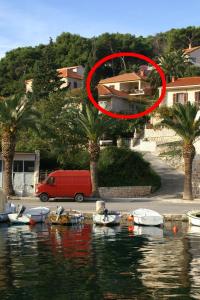 a red circle on a house with boats in the water at Apartments with parking space Splitska, Brac - 2857 in Supetar