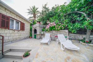a patio with two white chairs and a table at Apartments with parking space Splitska, Brac - 2857 in Supetar