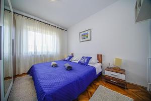 een slaapkamer met een blauw bed met 2 handdoeken erop bij Apartments with a parking space Splitska, Brac - 2857 in Supetar
