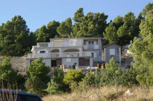 una casa en la cima de una colina con árboles en Isolated apartments with a parking space Cove Vela Farska, Brac - 2897, en Murvica