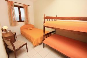 a bedroom with two bunk beds and a chair and a window at Isolated apartments with a parking space Cove Vela Farska, Brac - 2897 in Murvica