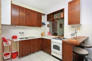 cocina con armarios de madera y horno de fogón blanco en Isolated apartments with a parking space Cove Vela Farska, Brac - 2897, en Murvica