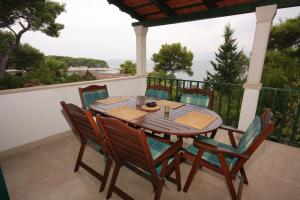 a wooden table and chairs on a balcony at Apartments by the sea Splitska, Brac - 2865 in Postira