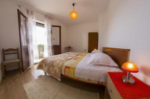 a bedroom with a bed and a red table with a lamp at Apartments by the sea Sumartin, Brac - 2951 in Sumartin