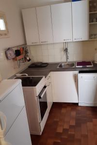 a kitchen with white cabinets and a sink at Apartments by the sea Sumartin, Brac - 2951 in Sumartin