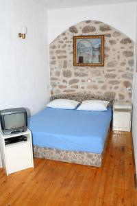 Schlafzimmer mit einem blauen Bett und einem TV in der Unterkunft Apartments with a parking space Bol, Brac - 2879 in Bol