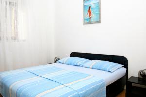 a bed in a bedroom with a picture on the wall at Apartments with a parking space Bol, Brac - 2879 in Bol