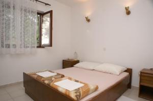 sypialnia z łóżkiem i oknem w obiekcie Apartments by the sea Milna, Brac - 2962 w mieście Milna