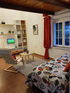 a bedroom with a bed and a chair and a window at Apartments by the sea Pucisca, Brac - 2927 in Pučišća