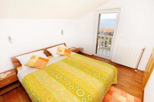 a bedroom with a bed with yellow sheets and a window at Apartments with a parking space Bol, Brac - 2900 in Bol