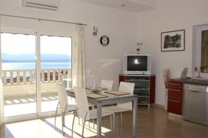 a kitchen and dining room with a table and a television at Apartments with a parking space Bol, Brac - 2900 in Bol