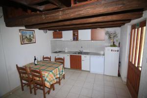 a kitchen with a table and chairs and a refrigerator at Holiday house with a parking space Bol - Brac - 2894 in Bol