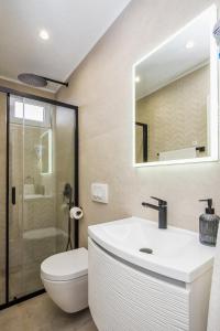 un bagno con lavandino, WC e specchio di Double Room Lokva Rogoznica 2973a a Lokva Rogoznica