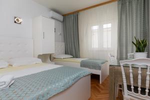 een hotelkamer met 2 bedden en een raam bij Apartments by the sea Duce, Omis - 2992 in Dugi Rat
