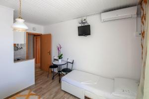 een woonkamer met een witte bank en een tafel bij Apartments by the sea Duce, Omis - 2992 in Dugi Rat