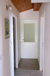 einen Flur mit einer weißen Tür und einer Holzdecke in der Unterkunft Apartments by the sea Tribunj, Vodice - 2993 in Tribunj
