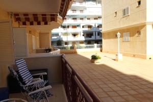 un balcón de un edificio con 2 sillas en Elvira Home, apartamento en La Mata, Torrevieja AQ-120, en La Mata