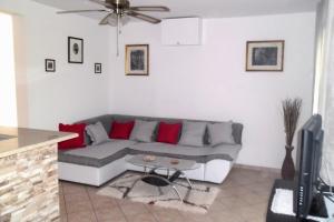 a living room with a gray couch and red pillows at Apartments by the sea Splitska, Brac - 2923 in Postira
