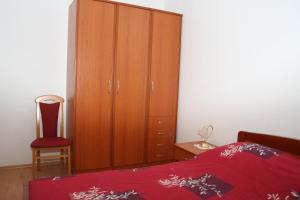 a bedroom with a wooden cabinet and a red bed at Apartment Bol 2884b in Bol