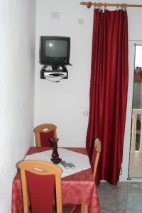 a room with a table with a tv and a red curtain at Apartment Bol 2884b in Bol