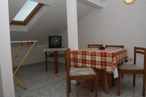 a dining room with a table and a television at Apartments with parking space Bol, Brac - 2884 in Bol