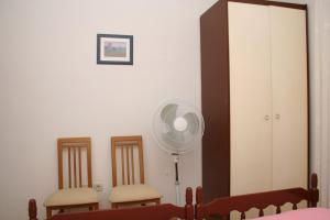 Double Room Sutivan 2943a في سوتيفان: غرفة بها كرسيين ومروحة ومرآة