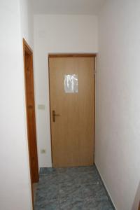 uma porta de madeira num quarto com um corredor em Double Room Sutivan 2943a em Sutivan