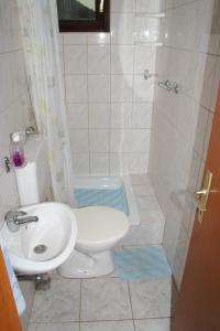 uma casa de banho com um lavatório, um WC e um chuveiro em Apartments and rooms by the sea Sutivan, Brac - 2943 em Sutivan