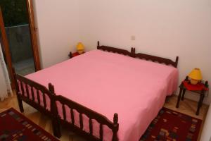 a bedroom with a large bed with a pink blanket at Apartments and rooms by the sea Sutivan, Brac - 2943 in Sutivan