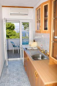 a kitchen with a sink and a view of the ocean at Apartments with a parking space Splitska, Brac - 2858 in Postira