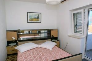 a small bedroom with a bed and a mirror at Apartments with a parking space Splitska, Brac - 2858 in Postira