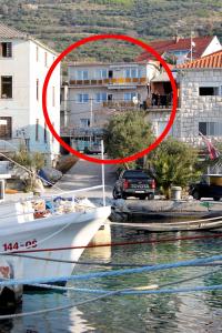 een boot in het water met een rode cirkel bij Apartments by the sea Sumpetar, Omis - 2965 in Jesenice