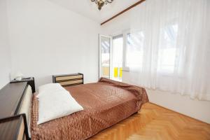 een slaapkamer met een bed en een groot raam bij Apartments by the sea Sumpetar, Omis - 2965 in Jesenice