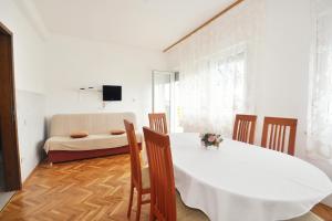 een eetkamer met een witte tafel en stoelen bij Apartments by the sea Sumpetar, Omis - 2965 in Jesenice