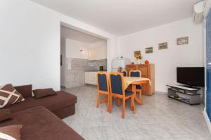 een woonkamer met een tafel en stoelen en een keuken bij Apartments with a parking space Pisak, Omis - 2827 in Mimice