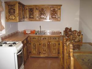 uma cozinha com armários de madeira e um forno de fogão branco em Cabanas El Cerrito em Zirahuén