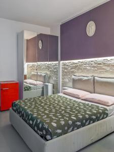una camera con un grande letto e pareti viola di Minimal Chic a Verona