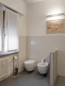 a white bathroom with a toilet and a sink at Minimal Chic in Verona