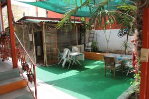 a patio with a green floor with a table and chairs at Limon Pansiyon in Edirne