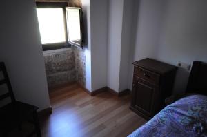 um quarto com uma cama, uma janela e um piso de madeira em Quinta Cale Breo. Vivenda Turística Rural 